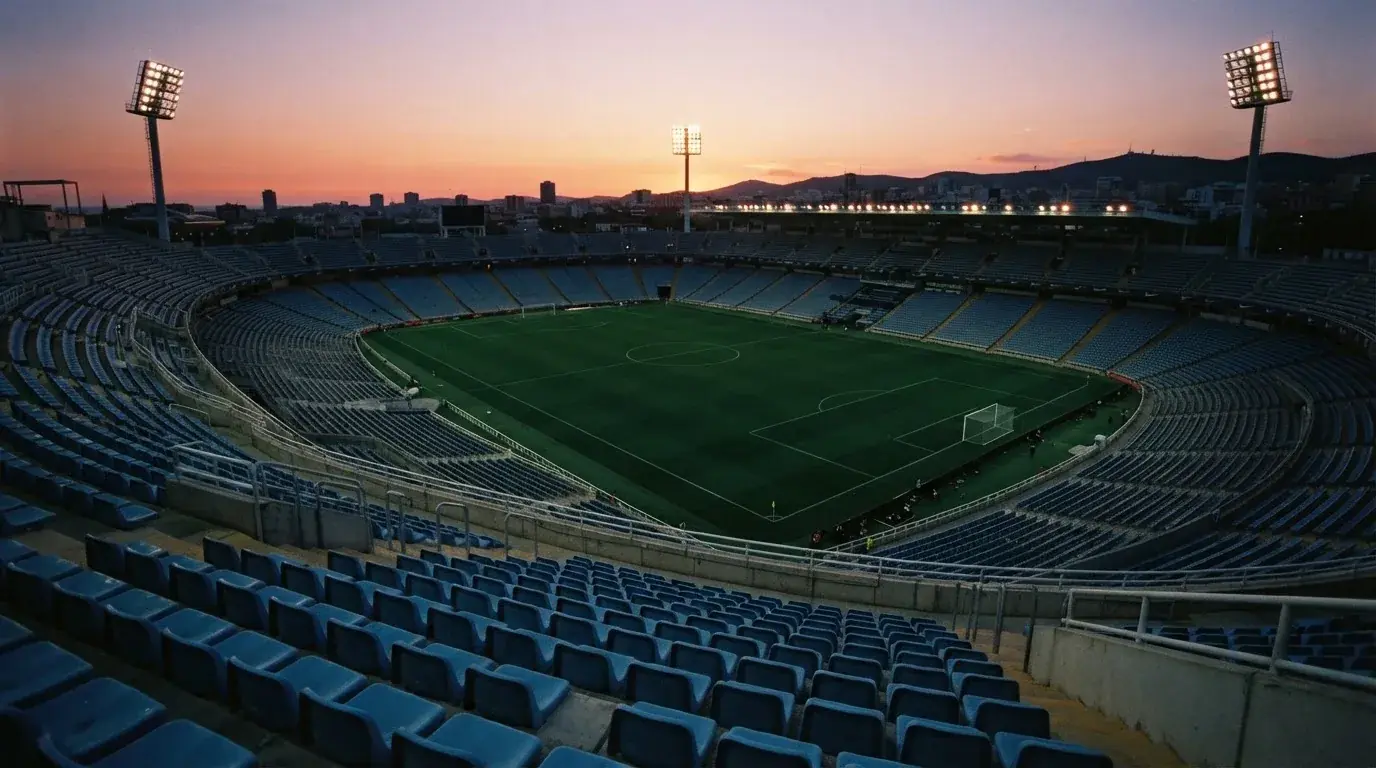 Un estadio de fútbol vacío con torres de iluminación al atardecer